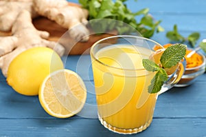 Immunity boosting drink and ingredients on blue wooden table, closeup