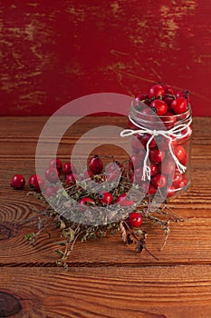 Immunity boosting treatments, infusions. Natural thyme, mint herbs and rosehip berries in a jar on a wooden background