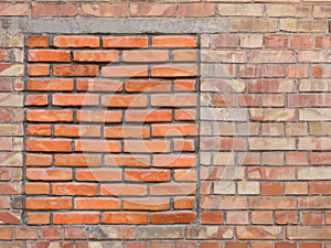 Immured bricked-up window on an old brick wall