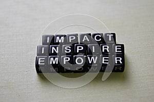 Impact - Inspire - Empower on wooden blocks. Business and inspiration concept