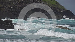 The impact of the waves on the cliffs or shoreline