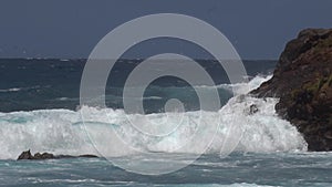 The impact of the waves on the cliffs or shoreline