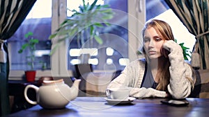 Impatient girl waiting for her boyfriend in cafe