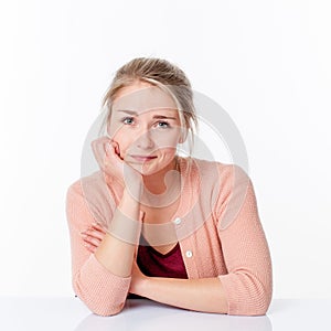 Impatient woman sitting in sparse office smiling with reflection