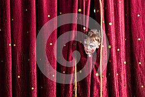 Impatient young actor peeking out from the curtain