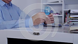 Impatiently Businessman Playing Restless with a Pencil in Hand on Desk Surface