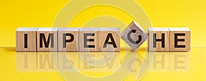 Impeache the word is written on a wooden block. The image is mirrored in the glossy surface. For your design, the concept is front