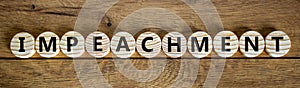 Impeachment symbol. Wooden circles with the word `impeachment`. Beautiful wooden background, copy space. Business, impeachment