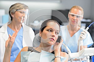 Impolite businesswoman on phone in dental office