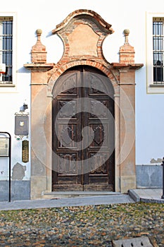 Imponent wooden door with a terracotta bricks arch.