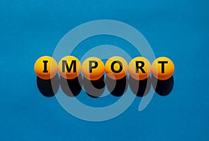 Import and business symbol. The concept word `import` on orange table tennis balls on a beautiful blue background. Business and