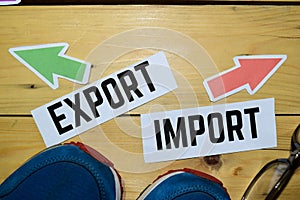 Import or Export opposite direction signs with sneaker and eyeglasses on wooden