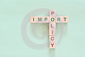 Import policy concept. Crossword puzzle flat lay typography in green background.