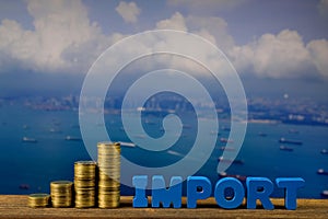 IMPORT text and stack of coin on wood table over seascape and ca