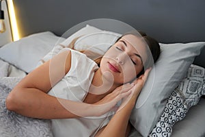 Importance of a good sleep. Young beautiful woman sleeps blissfully in the bed. Girl with regulated circadian cycle photo