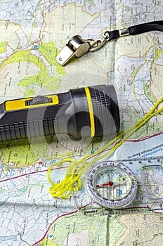 A hill walking map with compass torch and whistle.