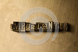 IMPORTANTLY - close-up of grungy vintage typeset word on metal backdrop photo