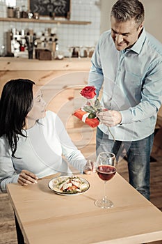 Imposing man surprising woman at cafe