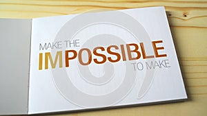 Impossible becomes possible by fading letters printed on the notebook page.