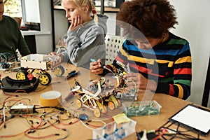 The impossible just takes a bit longer. Young engineer using soldering iron to join chips and wires. Robotics and