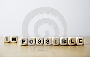 Impossible and possible wording on wooden cube block for changing negative to positive mindset in job and life concept photo