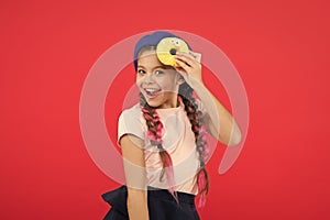 Impossible to resist fresh made donut. Girl hold glazed cute donut in hand red background. Kid playful girl ready to eat