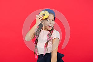 Impossible to resist fresh made donut. Girl hold glazed cute donut in hand red background. Kid playful girl ready to eat