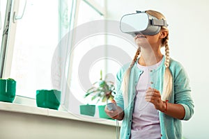 Impressed schoolgirl playing virtual games at school.