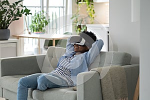 Impressions smiling African American young woman using VR headset immersing herself in metaverse