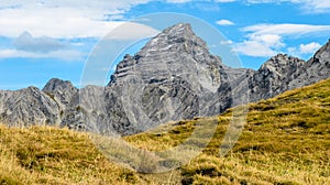 Impressive alpine peak with yellow grass