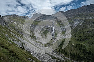 An impressive cirque of rocks in the mountains with a waterfall