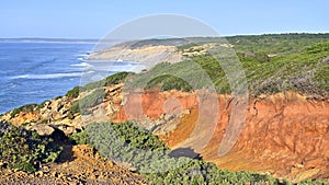 Impressive cliffs at Cape Espichel on coast of Atlantic Ocean in Portugal under blue sky.