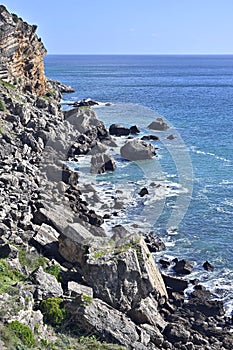 Impressive cliffs at Cape Espichel on coast of Atlantic Ocean in Portugal under blue sky