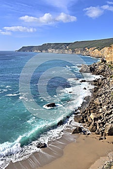Impressive cliffs at Cape Espichel on coast of Atlantic Ocean in Portugal under blue sky