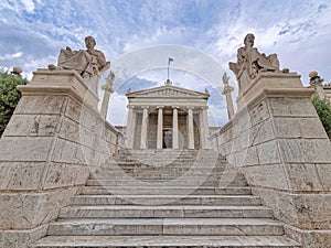 impressive sky over Plato and Socrates, the ancient Greek philosophers statues in front of the national academy of Athens