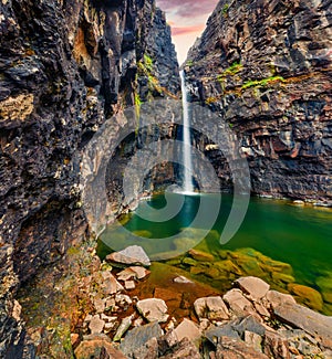 Impressive sunrise on waterfall in the outskirts of Haldarsvik village. Exciting summer scene of Streymoy island, Faroe, Denmark,