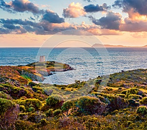 Impressive sunset view of Piscinni bay with Torre di Pixinni tower on background. Fantastic evening scene of Sardinia island, Ital