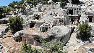 Impressive view of historical remains of Lycian rock tombs on slope of Mount Tocak in ancient city of Limyra in Turkey