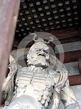 Impressive wooden statue at the entrance to a Japanese temple photo