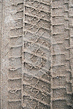 Imprint of car tire traces in the sand.