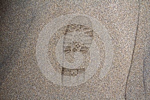 Imprint of the shoe on mud with copy space, Footprint in the dirt, Foot step on sand, background texture. Top view.