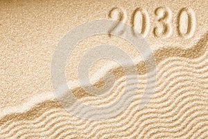 Imprints of numbers 2030 new year on a golden sand waves