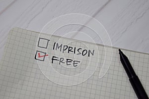 Imprison and Free write on a book. Supported by an additional services isolated wooden table photo