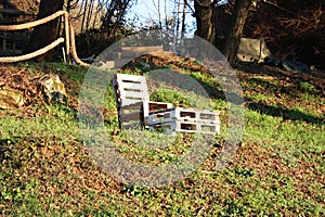 Impromptu chair. lying down in wood. Spartan craft creation made with plywood and advanced wood pieces in a downward clearing photo