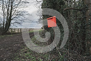 Impromptu red letter box seen outside a rural cottage along a dirt track. photo