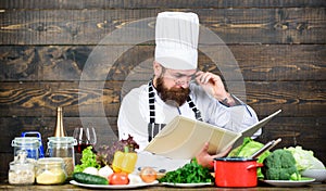 Improve cooking skill. Book recipes. According to recipe. Man bearded chef cooking food. Guy read book recipes. Culinary