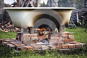 Improvised hot bathtub with fire underneath.