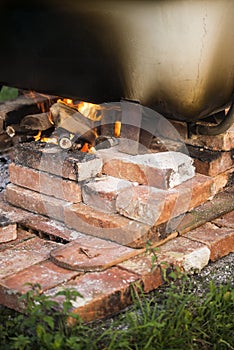 Improvised hot bathtub with fire underneath.