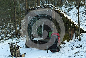 Improvised lean-to shelter in the winter forest