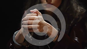 Impudent bored woman sitting in interrogation room, warming up wrists in cuffs